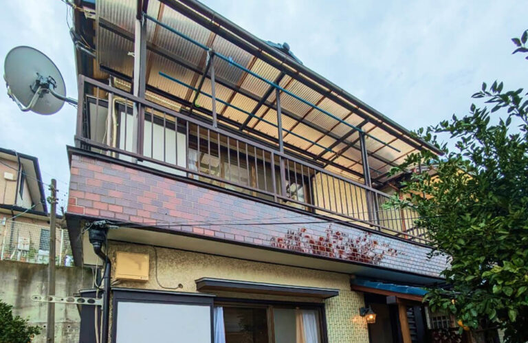 松戸市高塚新田の空き家買取事例：外壁やベランダに劣化がある2階建て住宅の外観
