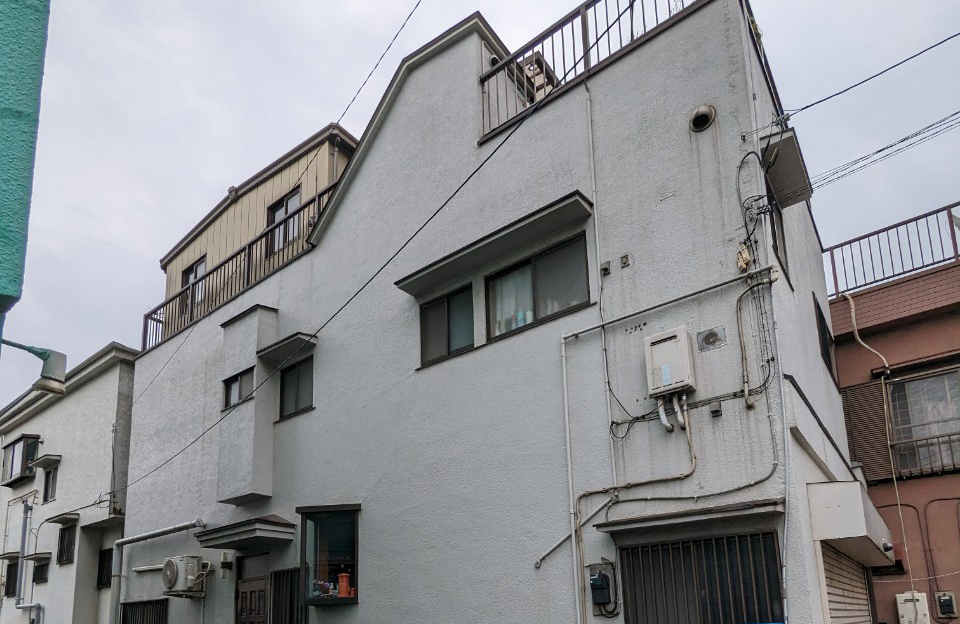 江戸川区松江で共有持分を買取した中古戸建の外観。外壁に経年劣化が見られる。細い路地に面した三階建ての建物。