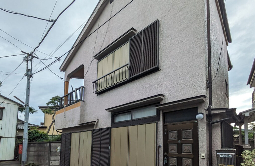 葛飾区高砂で買取した墓地前に位置する再建築不可の空き家の外観。雨戸が閉まった窓と古い玄関扉が並び、経年劣化が見られる戸建住宅。