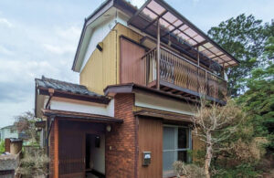 さいたま市緑区中尾の空き家買取事例：茶系とベージュの外壁が特徴の2階建て住宅の外観（経年劣化あり）