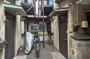 大田区東糀谷の再建築不可物件買取実績|建物が密集した敷地内通路と外観の様子