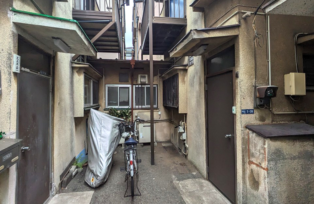 大田区東糀谷の再建築不可物件買取実績|建物が密集した敷地内通路と外観の様子