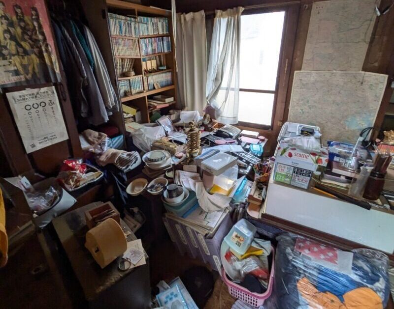 横浜市港北区仲手原2丁目　再建築不可　残置物あり物件　建物内写真（和室）テーブル上を生活雑貨が埋め尽くしている